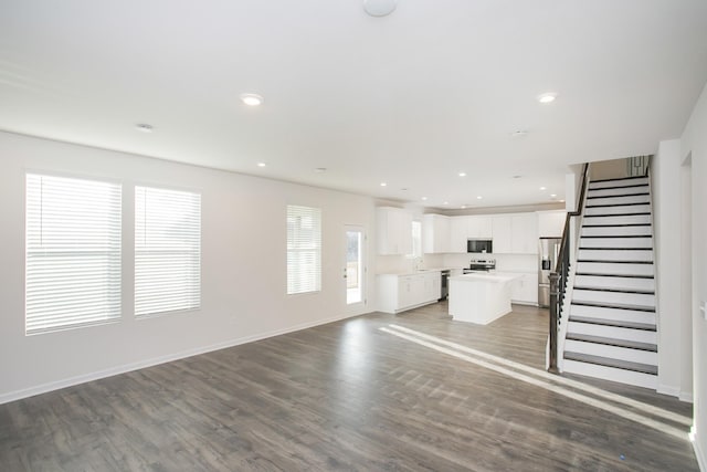 unfurnished living room with dark wood-type flooring and sink