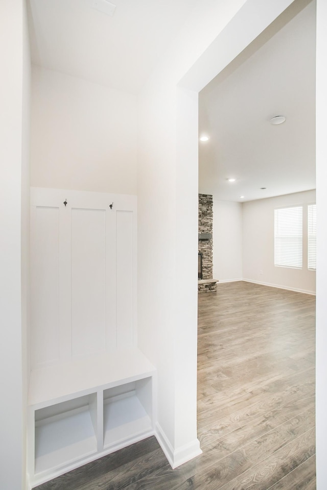 mudroom with hardwood / wood-style flooring and a fireplace