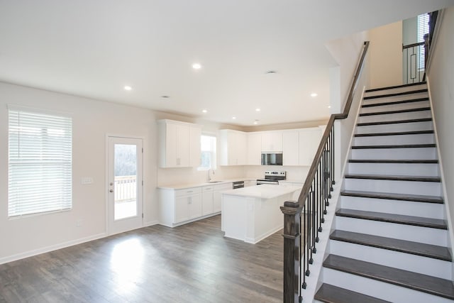 kitchen featuring sink, white cabinetry, dark hardwood / wood-style floors, a center island, and stainless steel electric range oven