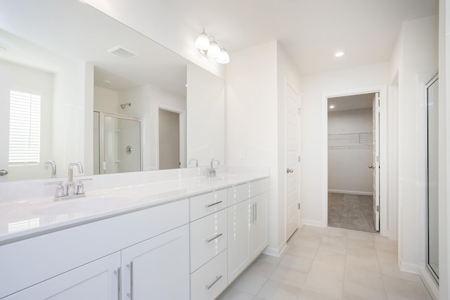 bathroom with vanity, tile patterned floors, and a shower with door