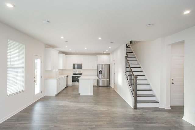 kitchen featuring a kitchen island, white cabinetry, sink, hardwood / wood-style flooring, and stainless steel appliances