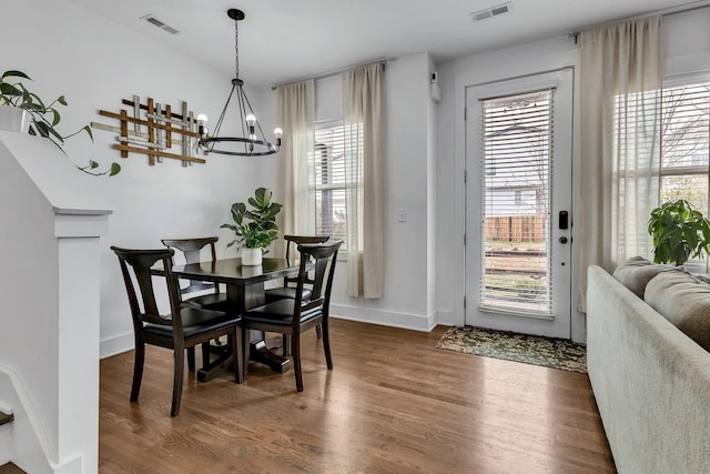 dining area featuring dark hardwood / wood-style floors and a chandelier