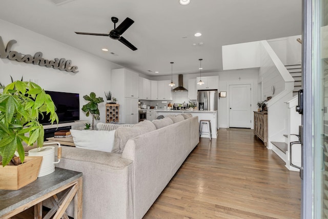 living room with ceiling fan and light wood-type flooring