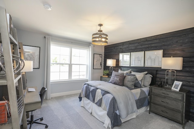 bedroom with light colored carpet and wood walls