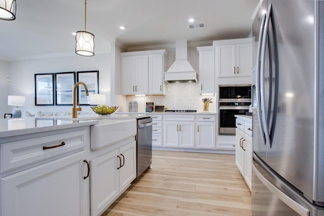 kitchen with premium range hood, pendant lighting, appliances with stainless steel finishes, and white cabinets