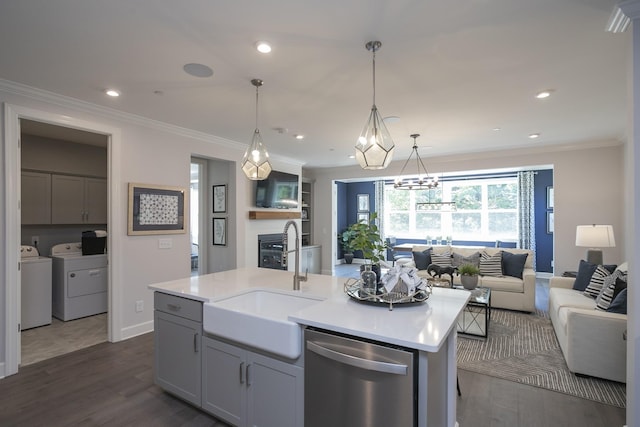 kitchen featuring sink, washer and clothes dryer, gray cabinets, dishwasher, and a center island with sink