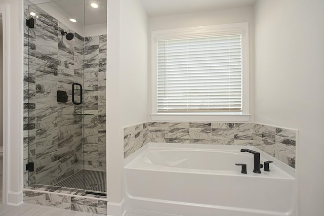 bathroom featuring independent shower and bath