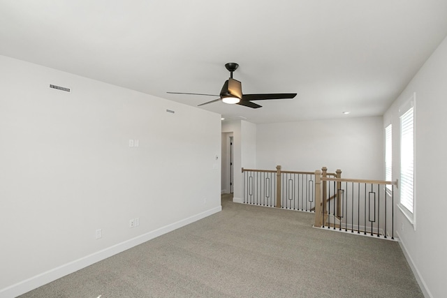 carpeted spare room featuring ceiling fan