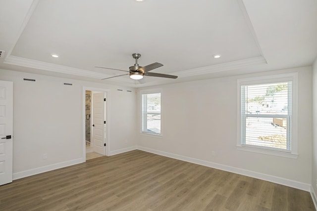 unfurnished room with crown molding, ceiling fan, light hardwood / wood-style floors, and a tray ceiling