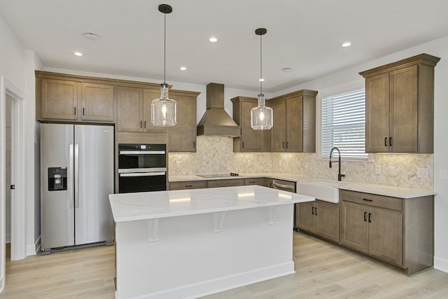 kitchen featuring stainless steel refrigerator with ice dispenser, custom exhaust hood, a center island, double oven, and pendant lighting