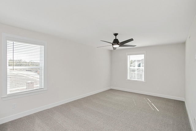 carpeted spare room featuring ceiling fan