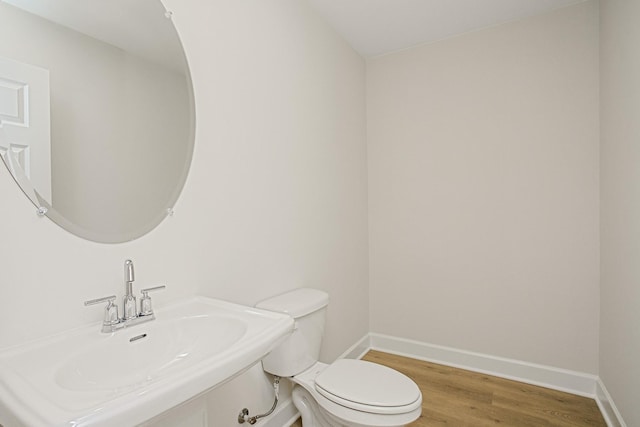 bathroom featuring wood-type flooring, sink, and toilet