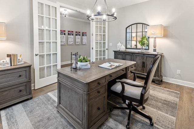 home office with an inviting chandelier, wood-type flooring, and french doors