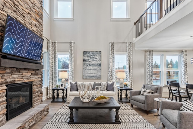 living room featuring a stone fireplace and hardwood / wood-style floors