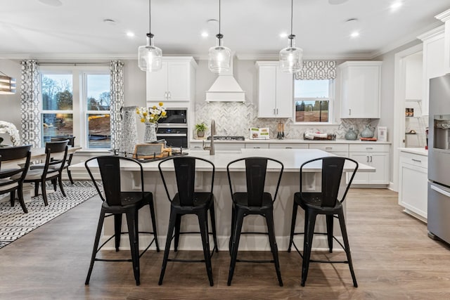 kitchen with wall oven, hanging light fixtures, built in microwave, and white cabinets