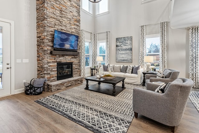 living room featuring hardwood / wood-style flooring, a high ceiling, and a fireplace