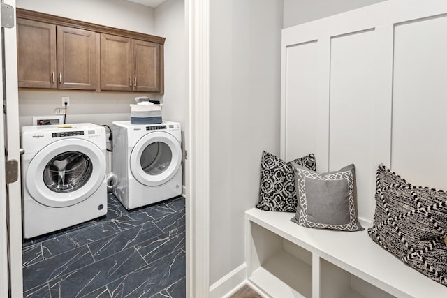 laundry area featuring washer and clothes dryer and cabinets