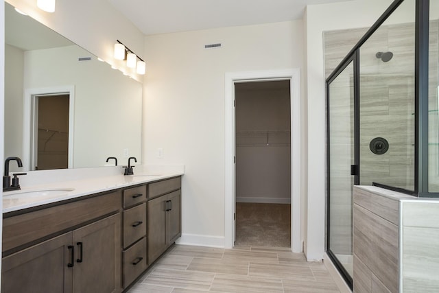 bathroom with vanity and a shower with door