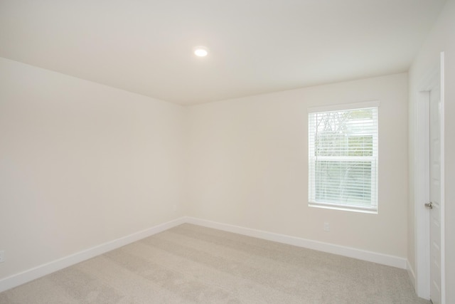 spare room featuring light colored carpet