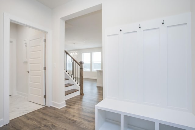 mudroom with hardwood / wood-style flooring and an inviting chandelier