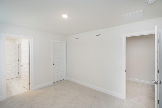 unfurnished bedroom with light colored carpet and ensuite bath