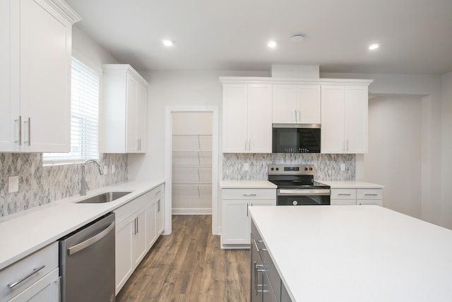 kitchen featuring stainless steel appliances, tasteful backsplash, sink, and white cabinets