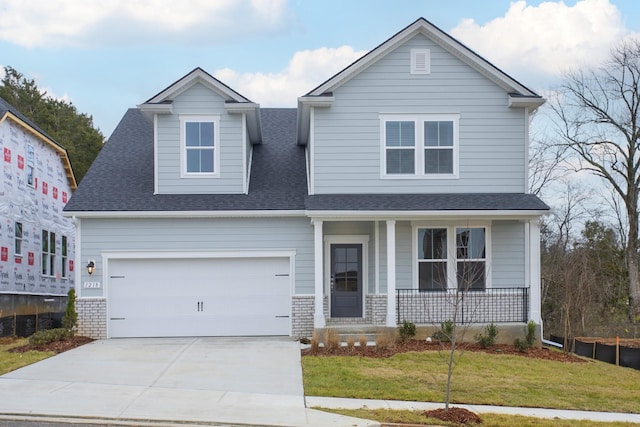 view of front of house with a garage, covered porch, and a front yard