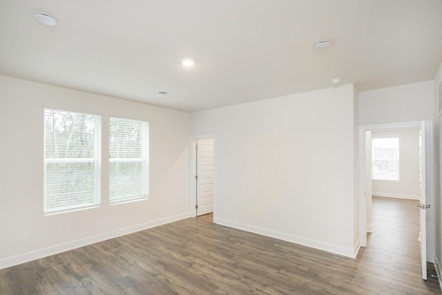 spare room with plenty of natural light and dark hardwood / wood-style floors