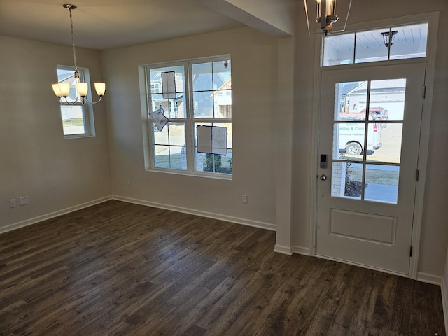 foyer entrance with an inviting chandelier and dark wood-type flooring