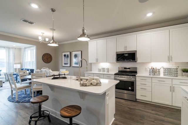 kitchen featuring decorative light fixtures, sink, white cabinets, a kitchen island with sink, and stainless steel appliances