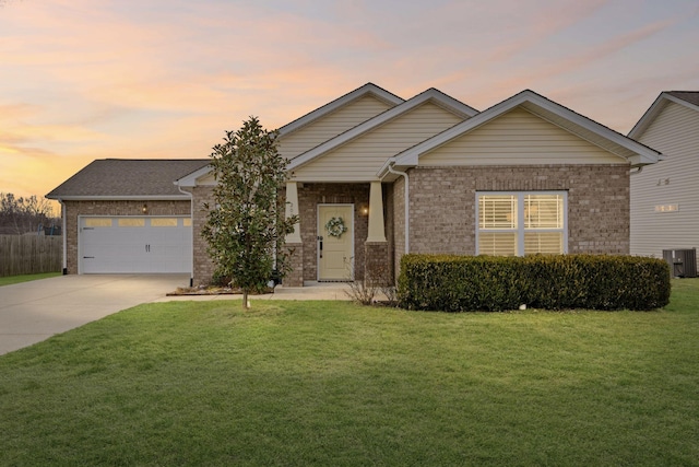 view of front of house featuring a garage, central AC unit, and a lawn