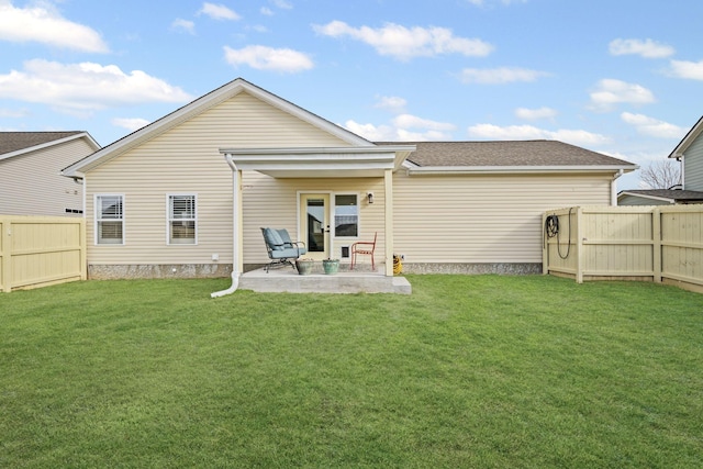 back of property with a patio area and a lawn