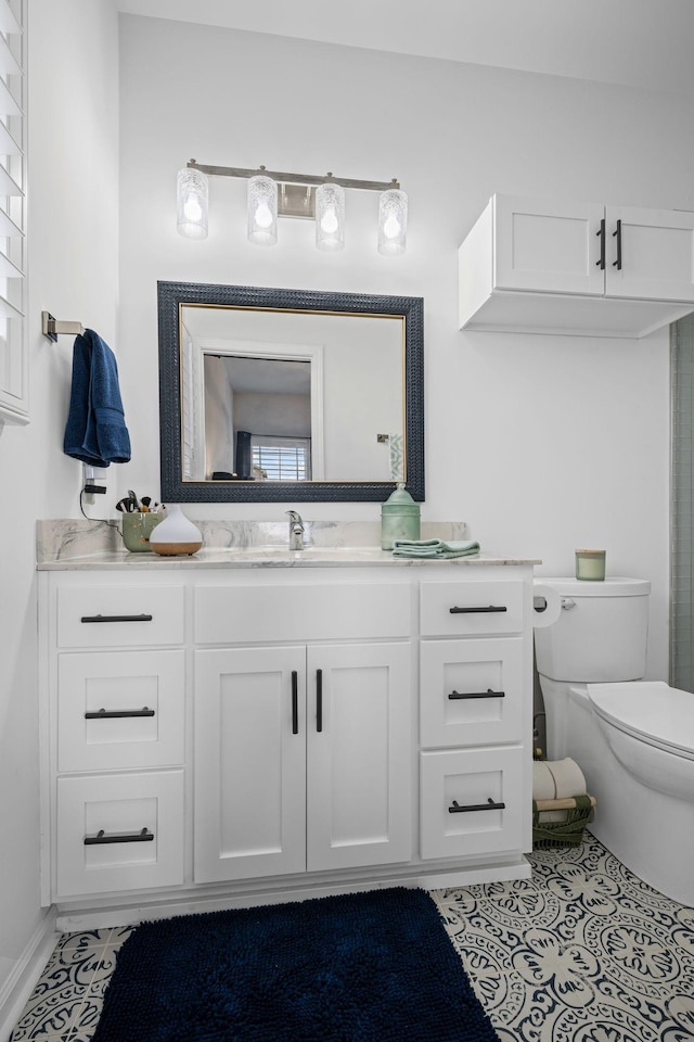 bathroom featuring vanity, tile patterned flooring, and toilet