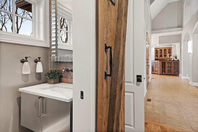 bathroom with tasteful backsplash, vanity, and tile patterned flooring