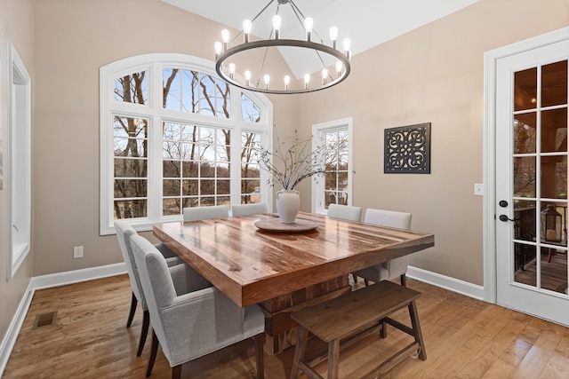 dining room with hardwood / wood-style flooring and an inviting chandelier