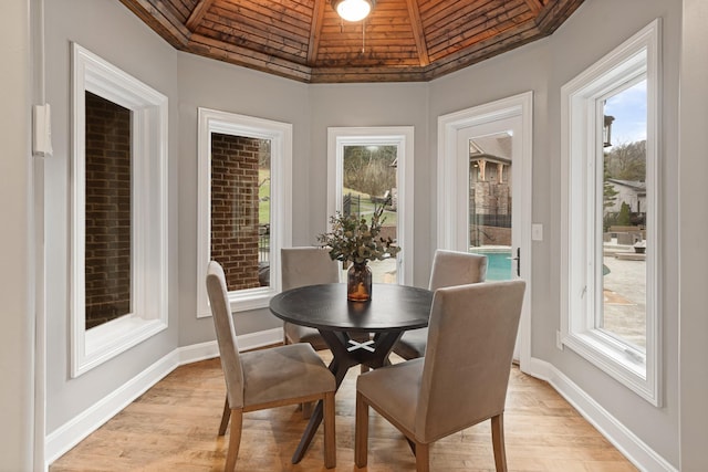 dining area featuring vaulted ceiling and light hardwood / wood-style floors