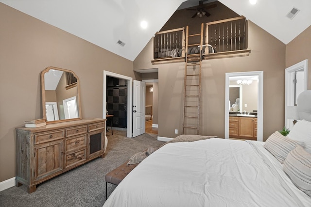 bedroom with a walk in closet, high vaulted ceiling, carpet, and ensuite bath