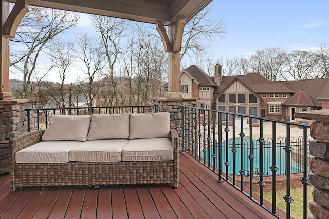 wooden deck with a pool and an outdoor hangout area