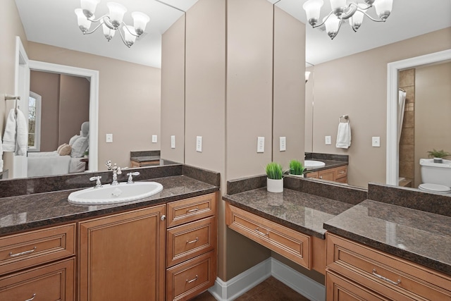 bathroom featuring an inviting chandelier, vanity, and toilet