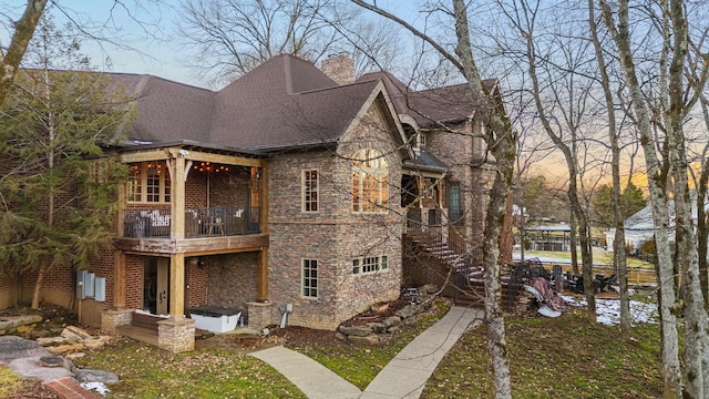 property exterior at dusk featuring a balcony