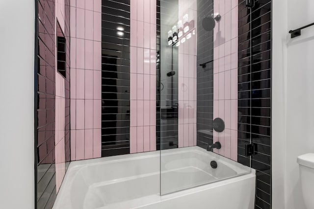 bathroom with tiled shower / bath combo and toilet