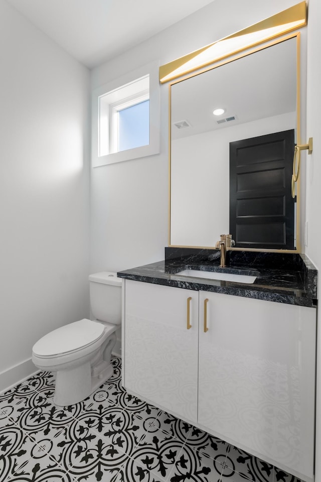 bathroom featuring tile patterned flooring, vanity, and toilet