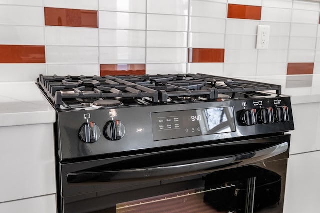 interior details featuring black gas stove and decorative backsplash