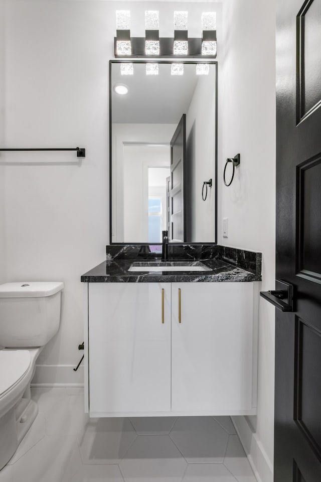 bathroom featuring tile patterned flooring, vanity, and toilet