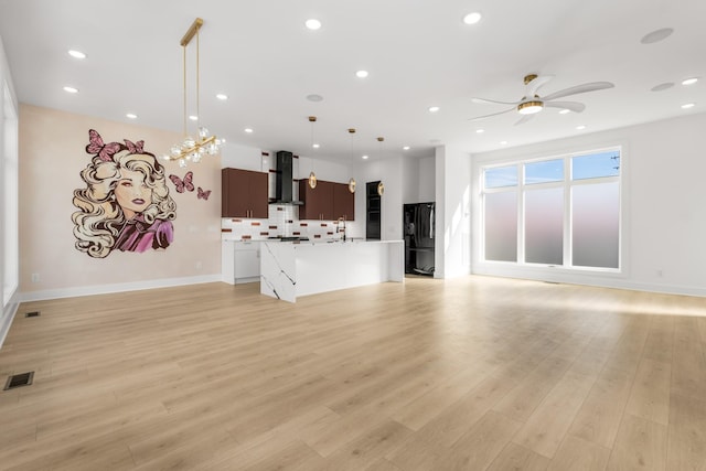 unfurnished living room featuring sink, light hardwood / wood-style floors, and ceiling fan