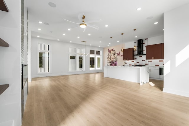 unfurnished living room featuring light hardwood / wood-style floors and ceiling fan