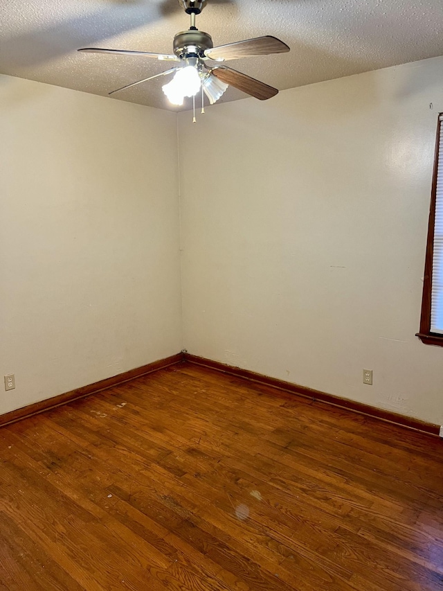 empty room featuring ceiling fan, wood-type flooring, and a textured ceiling