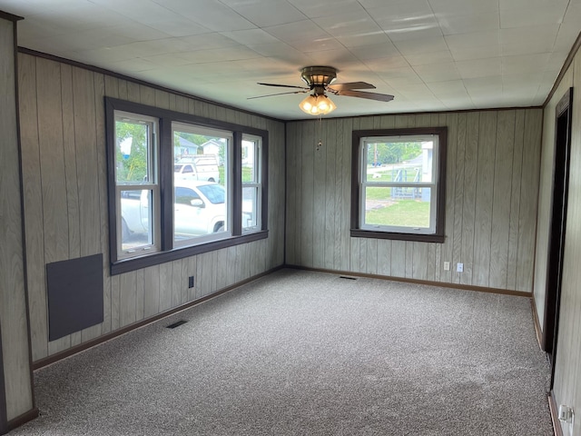 spare room featuring crown molding, carpet, and ceiling fan