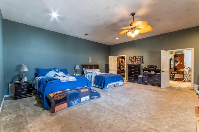 carpeted bedroom with a spacious closet and ceiling fan