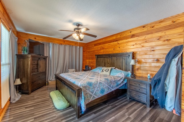 bedroom with ceiling fan, dark wood-type flooring, wooden walls, and a textured ceiling